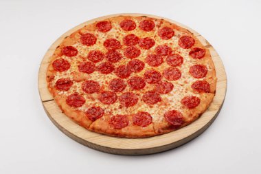 classic pepperoni pizza with tomato sauce and pepperoni sausages on wooden plate