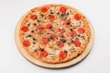 Pizza with tomato sauce, salami, olives and mushrooms served on wooden plate 