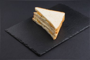 Siyah masada pastırmalı, peynirli ve yumurtalı beyaz ekmek. 