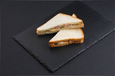 Siyah masada pastırmalı, peynirli ve yumurtalı beyaz ekmek. 