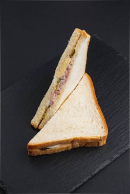 Siyah masada pastırmalı, peynirli ve yumurtalı beyaz ekmek. 