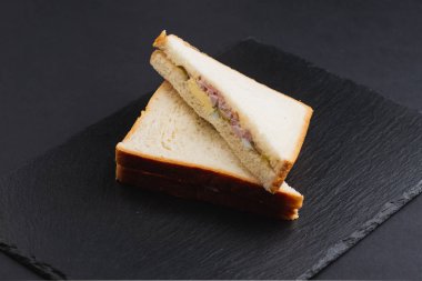 Siyah masada pastırmalı, peynirli ve yumurtalı beyaz ekmek. 