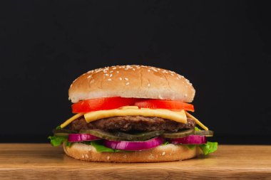 Yakın çekim, domatesli lezzetli hamburger, peynir, salatalık ve marul.