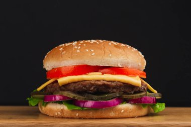 Yakın çekim, domatesli lezzetli hamburger, peynir, salatalık ve marul.