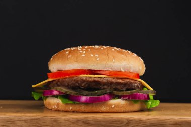 Yakın çekim, domatesli lezzetli hamburger, peynir, salatalık ve marul.