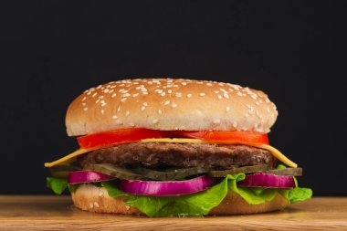 Yakın çekim, domatesli lezzetli hamburger, peynir, salatalık ve marul.