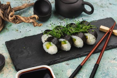 Siyah taş tabakta taze suşi yakın plan.