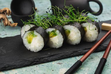 Siyah taş tabakta taze suşi yakın plan.