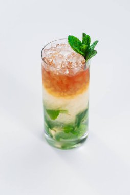 Erimiş buzla ve nane yapraklarıyla süslenmiş renkli alkol kadehleri.