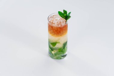 Erimiş buzla ve nane yapraklarıyla süslenmiş renkli alkol kadehleri.