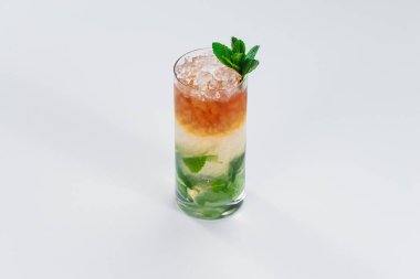 Erimiş buzla ve nane yapraklarıyla süslenmiş renkli alkol kadehleri.