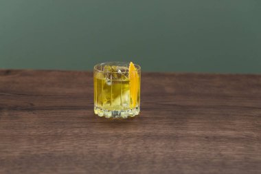 Sarı renkli alkol buzlu ve limon dilimli. 