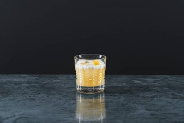 Karanlık arka planda bir bardak viski.
