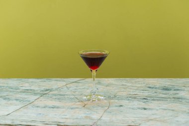 Altında kiraz olan bir kadeh kırmızı şarap. 