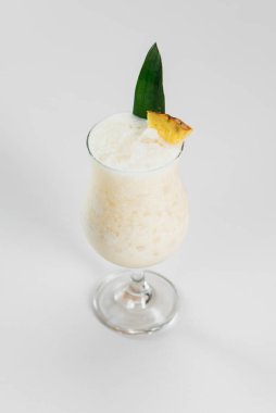 Yeşil yaprak ve meyvelerle süslenmiş süt kokteyli.