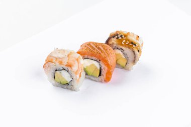 Beyaz arka planda izole edilmiş karides ve krem peynirli kırmızı somon suşi ruloları.