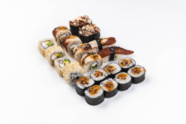 Renkli suşi seti nigiri ve somon, karides ve beyaz arka planda izole edilmiş krem peynirli füme yılan balığı ile suşi ruloları.