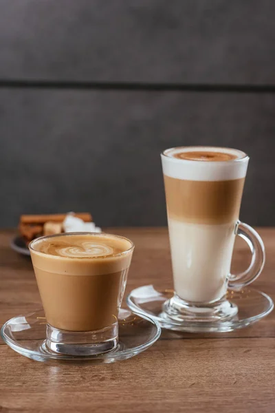 Latte Üveg Poharak Hab Fehér Barna Cukorszeletek Asztal Háttér — Stock Fotó