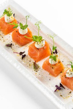 beyaz tabak somon dilimlenmiş krem peynirli ve yeşillikli 