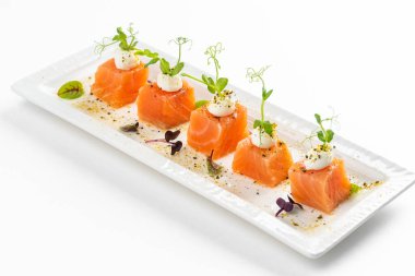 beyaz tabak somon dilimlenmiş krem peynirli ve yeşillikli 