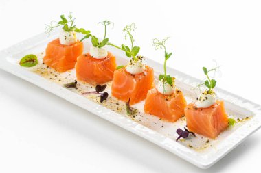 beyaz tabak somon dilimlenmiş krem peynirli ve yeşillikli 