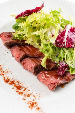 İtalyan salatası, et dilimleri, yeşiller ve beyaz tabakta kırmızı biber.