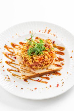 Baharatlı doğranmış et ve omlet. Beyaz ekmek tostları, yeşillikler ve bal sosuyla servis ediliyor. 