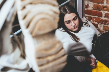 Kafenin arka planında oturan genç kadın.