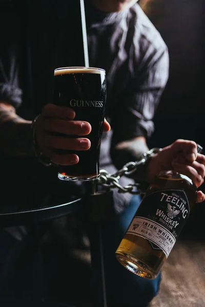 Jovem Barman Segurando Suas Mãos Vidro Cerveja Escuro Garrafa Uísque — Fotografia de Stock