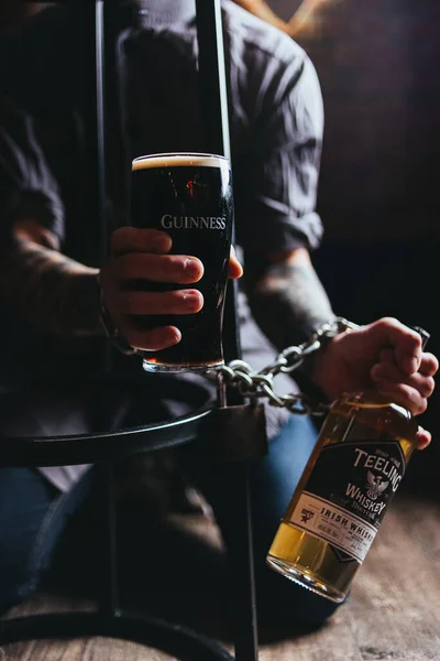 Jovem Barman Segurando Suas Mãos Vidro Cerveja Escuro Garrafa Uísque — Fotografia de Stock