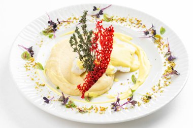 Patates püresi ve krema soslu fırında balık fileto otlar ve beyaz tabakta kırmızı kraker. 