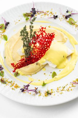 Patates püresi ve krema soslu fırında balık fileto otlar ve beyaz tabakta kırmızı kraker. 