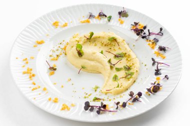 Beyaz tabakta tereyağlı ve yeşillikli yumuşak kremalı patates püresi 