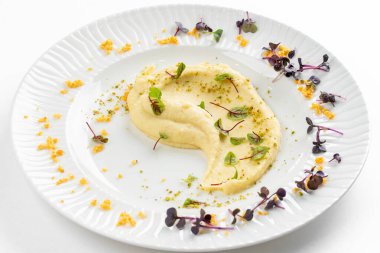 Beyaz tabakta tereyağlı ve yeşillikli yumuşak kremalı patates püresi 