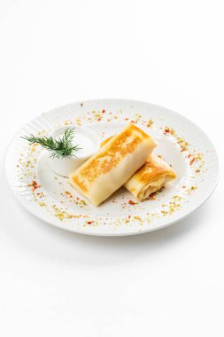 Rus krepleri altın hamurlu ve beyaz ekşi krema kasesi kırsal masa arkasında.