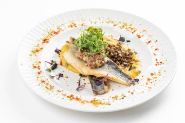 Patates püresi ve krema soslu balık filetosu otlar ve beyaz tabakta fasulye ile süslenmiş. 