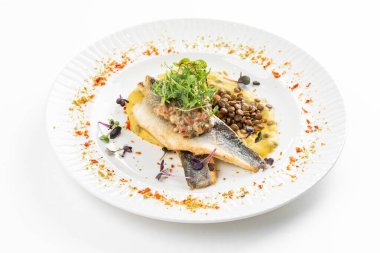 Patates püresi ve krema soslu balık filetosu otlar ve beyaz tabakta fasulye ile süslenmiş. 