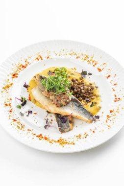 Patates püresi ve krema soslu balık filetosu otlar ve beyaz tabakta fasulye ile süslenmiş. 