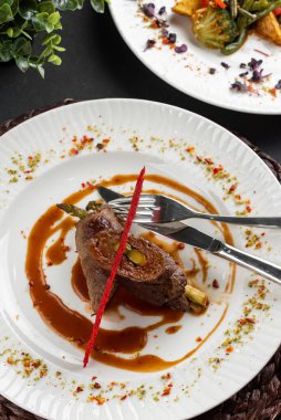 Kırmızı biberli kavrulmuş et, ahşap peçeteli beyaz tabakta karamelize edilmiş tatlı soğan manzarası