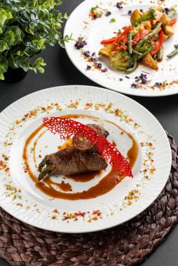 Kırmızı biberli kavrulmuş et, ahşap peçeteli beyaz tabakta karamelize edilmiş tatlı soğan manzarası