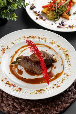 Kırmızı biberli kavrulmuş et, ahşap peçeteli beyaz tabakta karamelize edilmiş tatlı soğan manzarası