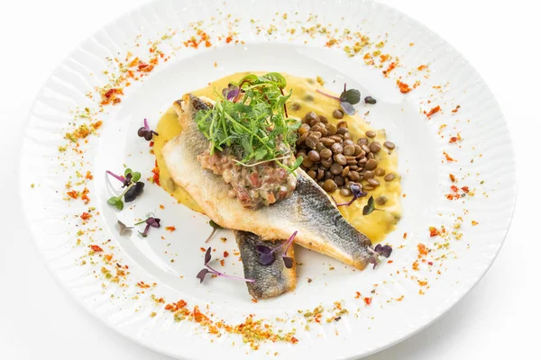 Patates püresi ve krema soslu balık filetosu otlar ve beyaz tabakta fasulye ile süslenmiş. 