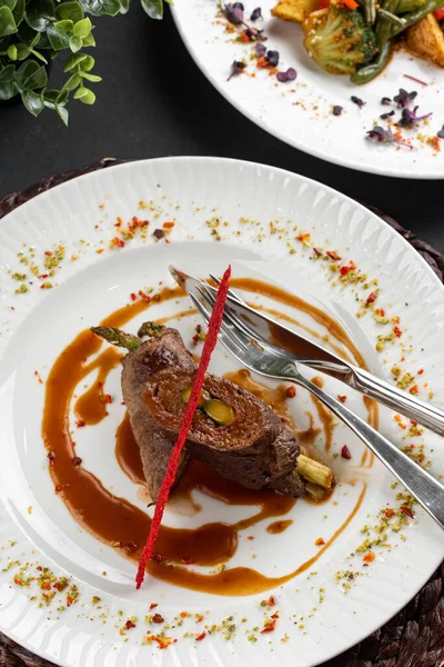 Kırmızı biberli kavrulmuş et, ahşap peçeteli beyaz tabakta karamelize edilmiş tatlı soğan manzarası