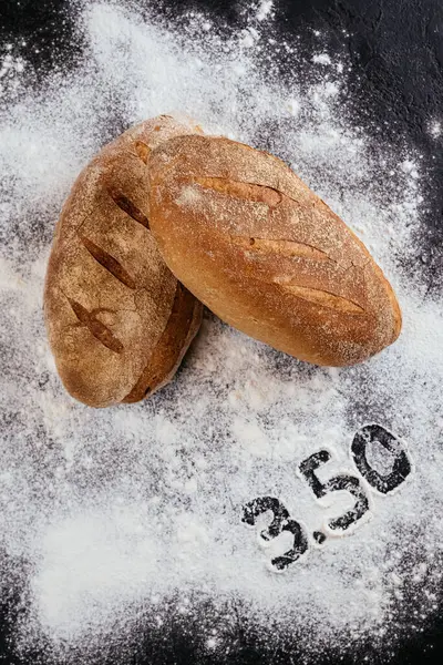 Biały Świeżo Pieczony Chleb Czarnym Tle Stołu Białą Mąką Liczbami — Zdjęcie stockowe