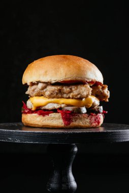 Lezzetli bbq cheeseburger ile et pirzolası, mantar ve siyah masa arkasında beyaz pişmiş çörekler.