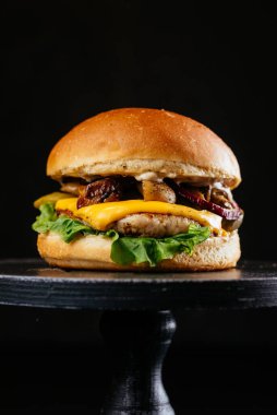 Köfteli köfte, ızgara mantar, peynir, taze salata yaprağı ve siyah ahşap masa arkaplanındaki sos.