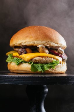 Köfteli köfte, ızgara mantar, peynir, taze salata yaprağı ve siyah ahşap masa arkaplanındaki sos.