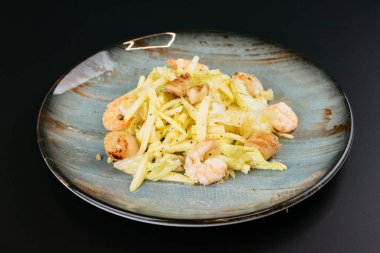 Siyah arka planda gri tabakta karidesli kızarmış patates.