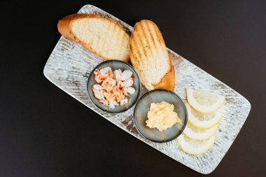 Krema soslu yengeç dilimleri ve limon dilimli ekmek kızartmaları. 