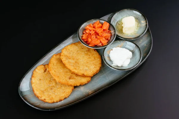 potato tortillas with sauces bowls on blue plates on black background